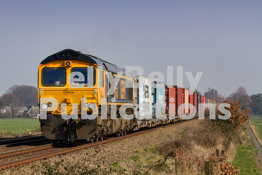 LPIS-D-DSL-CO-0007 
 GBRf Class 66 66745 approaches Heath Road foot crossing as it climbs away from Thurston towards Bury St. Edmunds with the 4E33 Felixstowe South to Doncaster container train on 12th March 2014. 
 Keywords: 66745, Class66, Colour, Container, Digital, East Anglia, Eastern, Freight, GBRf, Heath Road, Level Crossing, Rights Managed, Stock, Suffolk, Thurston