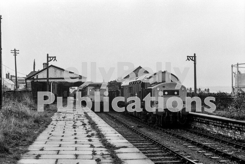 LPPC DSL BW 00723 
 The desolation of Pembroke Dock station is well defined on this miserable wet morning after the arrival of a WR Swindon Class 120 (Set C504) Cross Country DMU from Whitland. An English Electric Type 3 Class 37 waits to follow the DMU on its return journey. I often wondered whether anyone in Marylebone Road ever stopped to wonder whether their miraculous economies actually caused potential passengers to turn away from using rail, faced with what a dump this and many other stations had become with zero investment. 
 Keywords: BR, DMU, Wales, Western, Class 37, Coal, Passenger, Pembroke Dock, Class 120, C504