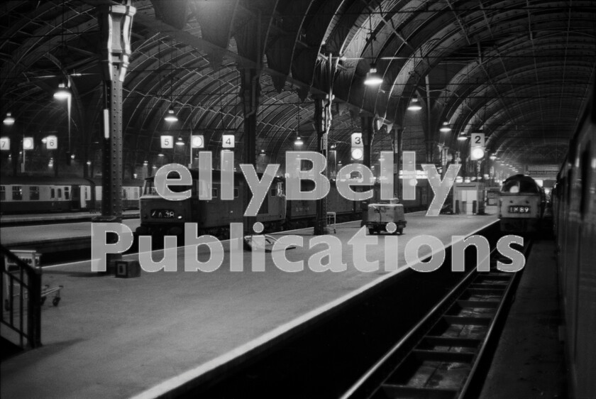 LPPC DSL BW 0577 
 Its around midnight at a strangely deserted Paddington one Friday night in April 1974. Waiting in platform 2 is the Western Class 52 that will head the overnight sleeper to Penzance, but first it has to pick up the Motorail GUV (General Utility Vehicle) from the loading ramp at the top of the platform at the buffer-stops before finally backing it, or them, onto the front of the sleeping cars. Over on platform 4 Hymek 7029 has a long, patient, wait at the head of a rake of GUVs and at least one Siphon G, before forming the early morning Thames Valley newspaper train. Over on platform 7 the stock is already in to form the 01.25am South and West Wales departure which ran via Gloucester and includes one of the relatively rare Mark 1 brake composites or BCK as they were coded. The Hymek was preserved and is currently undergoing restoration at the Severn Valley Railway by its owners, the Diesel Traction Group. 
 Keywords: Paddington, Western, Hymek, 1974, Passenger, Motorail, 7029, D7029, Parcels