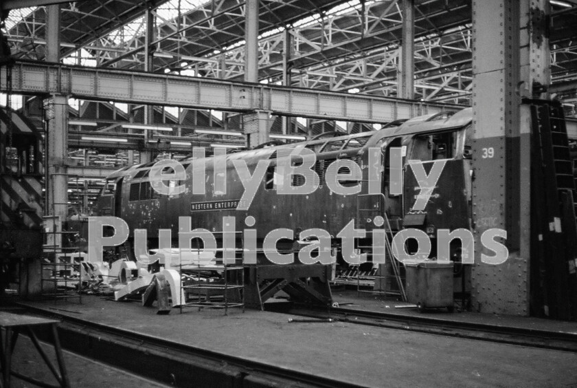 LPPC DSL CO 0200 
 The doyen of the Western Class 52s, number D1000 Western Enterprise, undergoes considerable work inside Swindon Works late in 1971. There were sharp intakes of breath when it was new, as it was originally turned out in a sort of beige/mustard colour officially referred to as Desert Sand. Perhaps the most well-known official photograph of it in this colour was taken heading a train of vans and waiting in the side parcels platform at Paddington, which was situated just beyond and to the left of the end of Platform One. Dark green was also tried on a few following examples before coaching-stock maroon was decided upon as the standardised colour for the class. The locomotive was in Swindon Works from 1st November 1971 until 29th March 1972, for conversion to dual Air Brakes and fitted with the Automatic Warning System (AWS) as part of an Intermediate repair. 
 Keywords: BR, 1971, Western, D1000, 'Western Enterprise', Swindon Works