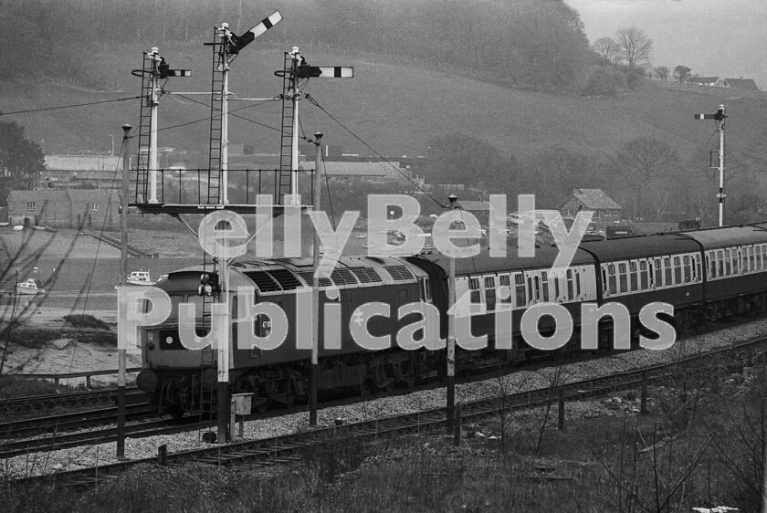 LPPC DSL BW 1160 
 Interlude at Llandudno Junction 1. Brush Type 4 Class 47 number 47100 looks reasonably smart as it approaches the junction with the branch to Llandudno town itself and passes under a superb bracket signal. It is heading an up train to London Euston from Holyhead and has just emerged from Conway bridge. 
 Keywords: Digital, ISO, John Stiles