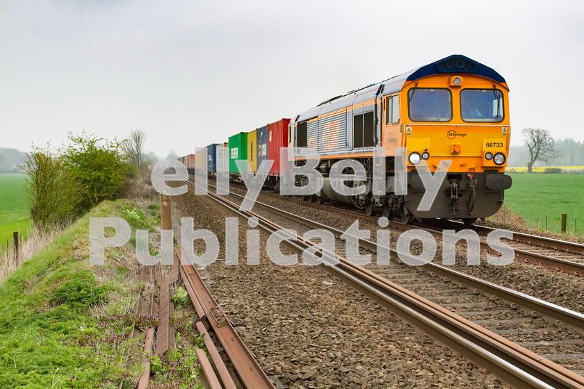 LPIS-D-DSL-CO-0020 
 GBRf Class 66 66733 approaches Heath Road foot crossing as it climbs away from Thurston towards Bury St. Edmunds with the 4E33 Felixstowe South to Doncaster container train on 4th April 2014. 
 Keywords: 66733, Class66, Colour, Container, Digital, East Anglia, Eastern, Freight, GBRf, Heath Road, Level Crossing, Rights Managed, Stock, Suffolk, Thurston