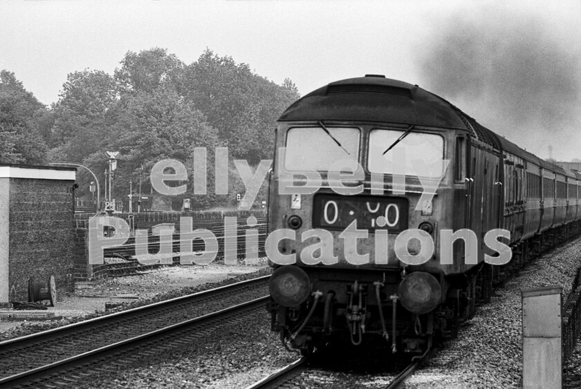 LPPC DSL BW 0409 
 Applying full power as it approaches the end of the 75mph speed restriction area out of London, a Class 47 Brush Type 4 (possibly 47509) heads a down express through Ealing Broadway on a summer Saturday evening. On the left, in the background, can be seen the extensive London Transport trackwork at the exit of the terminus of the Central Line. The stock is one of the WRs recently acquired Mark 2D sets, always with Mark 1 catering vehicles and BGs. I wonder if the headcode panel was set like it is on purpose? Second from the right looks like a 21st century emoji. 
 Keywords: Ealing Broadway, BR, Western, Class 47, 47509, Passenger