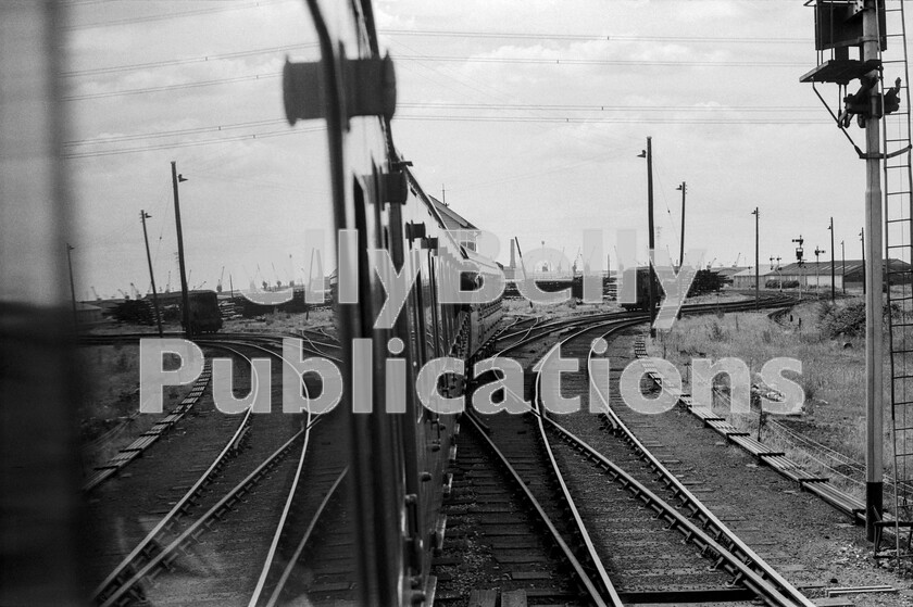 LPPC DSL BW 0627 
 During a Branch Line Society tour of South Wales, the DMU formation stops at Alexandra Dock Junction, Newport for the crew to change ends and reverse. Although it looks like imminent disaster might occur with the Class 08 just ahead, it was a Saturday and the latter was shut down and stabled. The then vast site of Newport Docks is clearly visible on the horizon. 
 Keywords: BR, Newport, Alexandra Dock Junction, DMU, BLS, Branch Line Society, Railtour, Class 08, Docks, Passenger