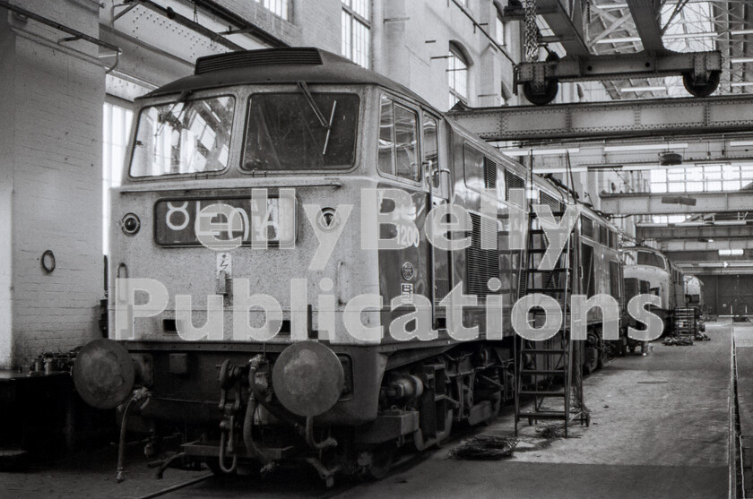 LPPC DSL BW 0965 
 Originally numbered D0280 and named Falcon as a prototype diesel locomotive in 1962, it had emerged from the Brush works with Maybach engines as a possible standard second-generation Type 4 to replace the Class 40s and spent time on the ER under test conditions, but in normal traffic. By the time this shot was obtained in late 1971 inside Swindon Works, it had been demystified and assimilated into the system as plain 1200. Allocated to Bath Road Bristol 82A it was used from there, almost as a common-user engine, on InterCity trains to and from London. As part of an unusual agreement, BR had purchased the loco outright from Brush at scrap value on condition that it was actually scrapped when BR had finished with it, and this finally happened in late 1975. The closest Warship is 862 Viking, withdrawn on 3rd October 1971 and is being stripped of usable spares before being broken up. 
 Keywords: BR, Western, Swindon Works, D2080, 1200, Falcon, 1971