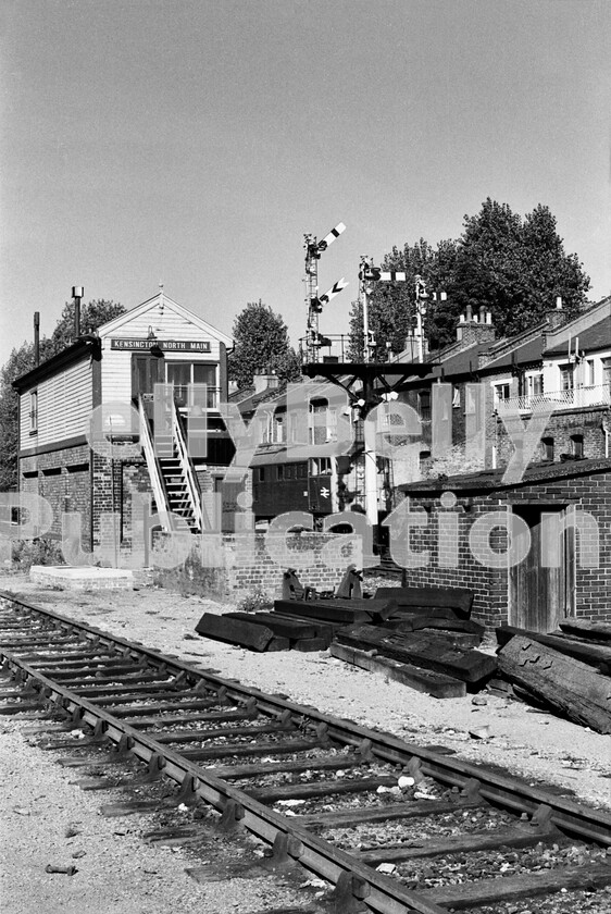 LPPC DSL BW 0317 
 A quiet moment one summers morning at Kensington Olympia in 1971 as a Brush Type 2 Class 31 gets underway from a signal stop outside the North signalbox, with a cross-London freight for Hither Green.

This is a fascinating glimpse during the long evolution of BR from Victorian masterpiece of the world to state-of-the-art modern railway. The signalbox, signals and general infrastructure are firmly from the past and even the locomotive, by this time, is coming up for its 12th birthday, longer on the rails than many of BRs Standard classes of steam engine managed. Mind you, the budget available for change from the public purse was tiny, compared to the huge amounts thrown at todays privatised rail franchises. 
 Keywords: BR, Kensington Olympia, Western, Class 31, Freight, 1971