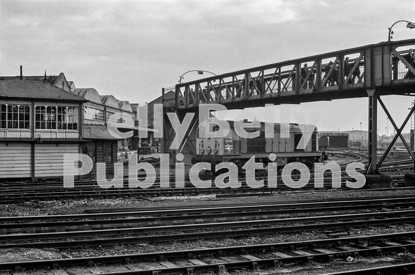 LPPC DSL BW 0501 
 Whilst waiting to come off the TMD at Derby to take up its duties, English Electric Type 1 Class 20 number 20005 ticks over sounding like a slightly muted Class 40, both types constantly revealing their power-units EE origins. It is time for a shift change at Derby BREL, as can be seen by the pedestrians on the long footbridge connecting the works to the outside world. The internal tracks and sidings are still controlled by the typical Midland Railway signal box on the left. I hope the medieval-looking ladder propped up next to it isnt used for anything serious. I well remember crossing the bridge with a lot of other spotters in huge anticipation of what we might see, having arrived from St Pancras behind a rebuilt West Country Pacific 34031 Torrington on an Ian Allan special in 1962.