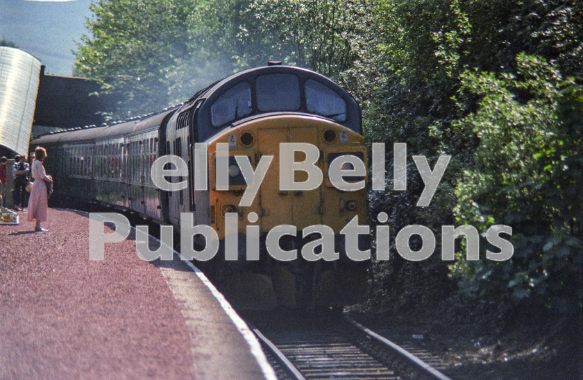 LPAP-DSL-CO-0134 
 Slowing for the Helensburgh Upper stop, 37037 is hauling the 0950 Glasgow - Fort William, 30th May 1985. 
 Keywords: BR, Midland, LMS, Scotland, Helensburgh, Diesel, BR, Passenger, Colour, Class37, 37037, D6737, MR, 1985