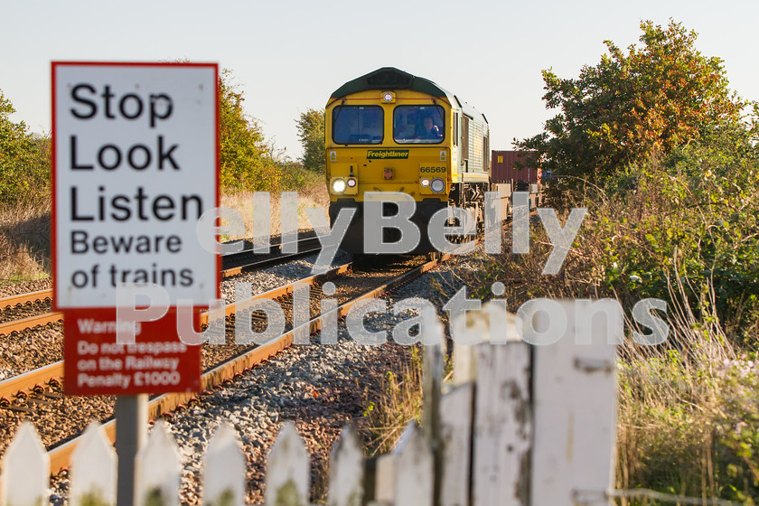 LPIS-D-DSL-CO-0001 
 Freightliner Class 66, 66569 approaches Catteshall level crossing as it descends towards Bury St. Edmunds with the heavily delayed 4E62 Felixstowe to Doncaster Europort container train on 30th October 2013. 
 Keywords: 66569, Bury St. Edmunds, Catteshall, Class66, Colour, Container, Digital, East Anglia, Eastern, Freight, Freightliner, Level Crossing, Rights Managed, Safety, Stock, Suffolk