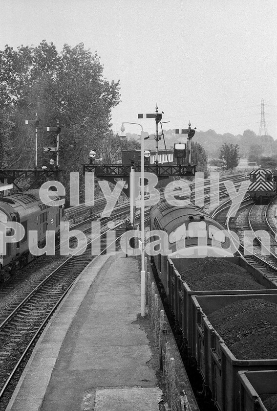 LPPC DSL BW 1290 
 For the bobby, its all happening one lunchtime at Radyr as two English Electric Type 3 Class 37 workhorses (37225 is seen on the left) of the Welsh Valleys are brought to a stand, ready for the road. On the right, the secondman is on the phone probably making clear the fact that he considers he has priority over the sibling machine on the left and could someone do something about it asap. 
 Keywords: BR, Radyr, Western, Wales, Class 37, 37225, Coal, Freight, Class 08