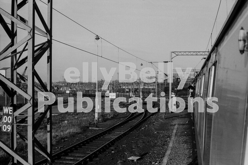 LPPC DSL BW 0662 
 Since the beginning of inter-regional passenger traffic from the West Coast line north of the Thames to the south, pioneered by the LNWR/LBSCR Sunny South Express, locomotive changes have taken place at Mitre Bridge Junction, Willesden and here a Merrymaker Excursion from the Medway towns and south-east London to Birmingham and Wolverhampton in the early 1970s has shed its Southern Type 3 Class 33 diesel for an AC lines electric and is about to make a swift run to Britains second city. It is early in the morning and the train has travelled via Herne Hill, Stewarts Lane and Latchmere junction to gain the colloquially named West London Extension line via Kensington Olympia. We were using this train as a means to travel onwards to Chester  see the Class 24 photographed there that day later in this book  via Shrewsbury and return via Crewe to Wolverhampton. It was a very long day. 
 Keywords: Digital, Rights Managed, Stock