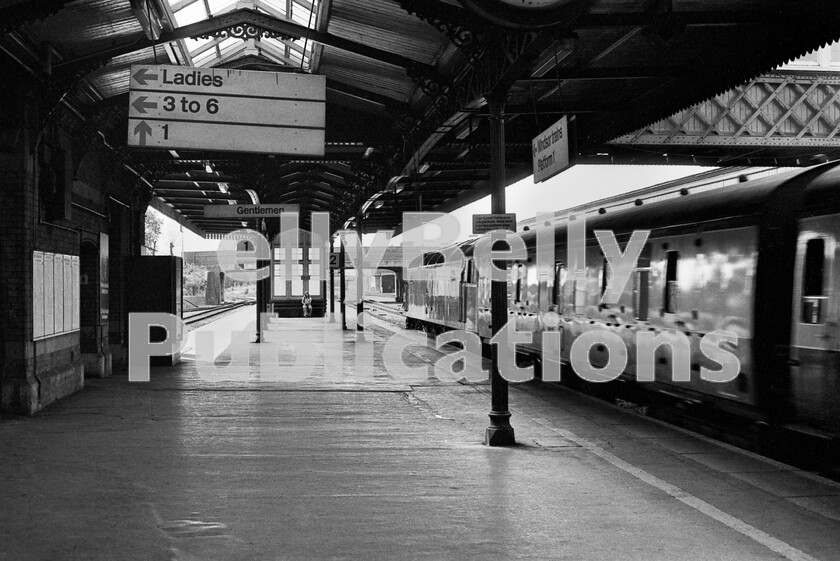 LPPC DSL BW 0894 
 You can almost feel the air being shoved out of the way by this Brush Type 4 Class 47 as it slams through Sloughs down main platform with an Inter City for the west. The station still retains much GWR atmosphere from the glass behind the lone seated passenger, to the iron-work supporting the awnings. On the left is the Windsor Central branch bay. The line itself diverges to the left just beyond the road bridge, whilst on the right-hand side was the, now closed, branch into Slough Estates, which was one of the first industrial estates in the UK, established in the 1930s. 
 Keywords: BR, Passenger, Slough, Class 47, Western