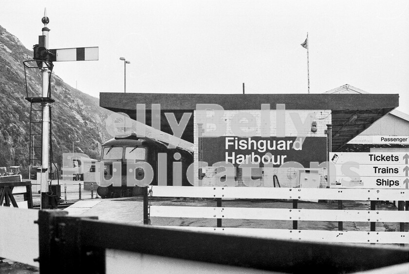 LPPC DSL BW 00722-Edit 
 Fishguard Harbour station was never a particularly attractive place to have to spend time and on an early autumn weekday afternoon it certainly doesnt look at its best. It really only existed as an interchange point for travellers to and from the Rosslare Irish ferries, but it was possible to visit as an ordinary, inquisitive, passenger. Fishguard and Goodwick station, less than a mile up the line, was more appropriate for local travellers. Here the afternoon ferry connection has arrived from London Paddington in the late 1970s and the Brush Type 4 Class 47 has run round the stock and is ready for an imminent departure. It was a simple in and out job, with minimal waiting time. Under the current timetable there are two round trips to the station per day to connect with the ferries. The late evening train meets a ferry and departs around 23.00pm, but terminates at Carmarthen, leaving passengers with a five hour wait if they wish to travel further east on the first service of the day. 
 Keywords: BR, Western, Wales, Class 47, Fishguard Harbour, Passenger