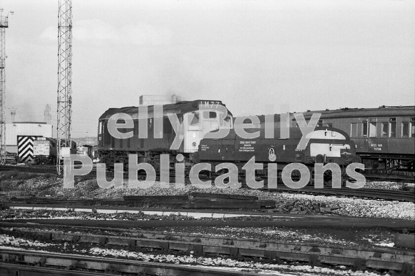 LPPC DSL BW 0819 
 There was, it seemed, an endless stream of locos going on and off shed with little time between each movement. How both the industrial map of the UK and the railway have changed today. Here, Sulzer Type 2 Class 25 number 5227 (later 25077), still wearing what was left of its original lined green livery and BR heraldic device, trundles from the yards to the shed dragging a diesel brake-tender behind it having powered a coal trip earlier in the morning. These were truly mixed-traffic engines if the headcode in its roofbox is to be believed, as that suggests a previous Class 1 passenger working. The locomotive was making one of its last journeys in the East Midlands as it was transferred to Ebbw Junction, Newport on the 8th January 1972. 
 Keywords: Digital, Rights Managed, Stock