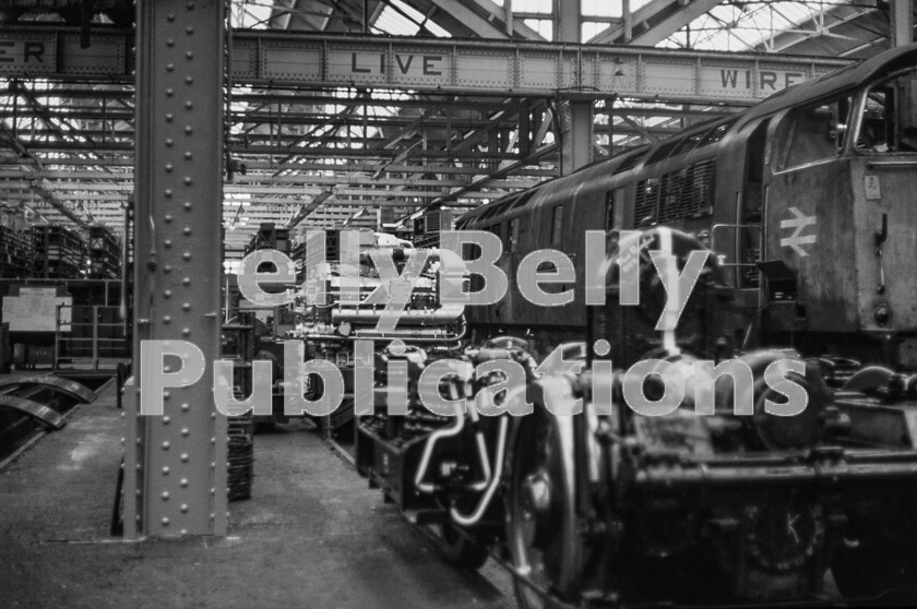 LPPC DSL CO 0208-Edit 
 Western Class 52 Western Emperor D1036 is in Swindon Works in winter 1971 for major mechanical work including an engine and bogie change. The new or refurbished components, with the engine displaying a turbocharger and a fluid coupling on the bogie, along with the bulk of the loco itself, are dwarfed by the massive scale of the GWRs Swindon Works main erecting shop. It is not difficult to imagine rows of anything from Kings to Pannier Tanks awaiting work and final painting to gleaming condition in this enormous building. It is to be hoped that something was done about the locos shabby exterior too. D1036 was in Swindon Works from 20th October 1971 until 8th March1972, for conversion to dual Air Brakes and AWS as part of an Intermediate repair. 
 Keywords: BR, Western, Class 52, Swindon Works, D1036, 'Western Emperor', 1971