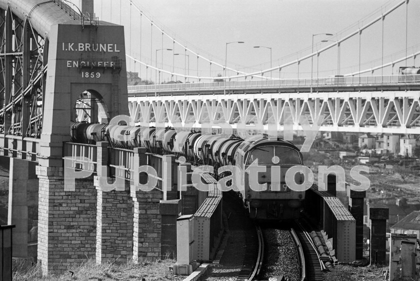 LPPC DSL BW 0402 
 A crisp spring Sunday in March 1973 sees a Western Class 52 diesel hydraulic idle off Brunels superb Saltash bridge as it heads the daily Penzance to Kensington milk train out of Cornwall into Devon and along the sinuous section of the GWR on the way to Plymouth and beyond. 
 Keywords: BR, Western, Class 52, Milk, Freight, Saltash Bridge, Plymouth