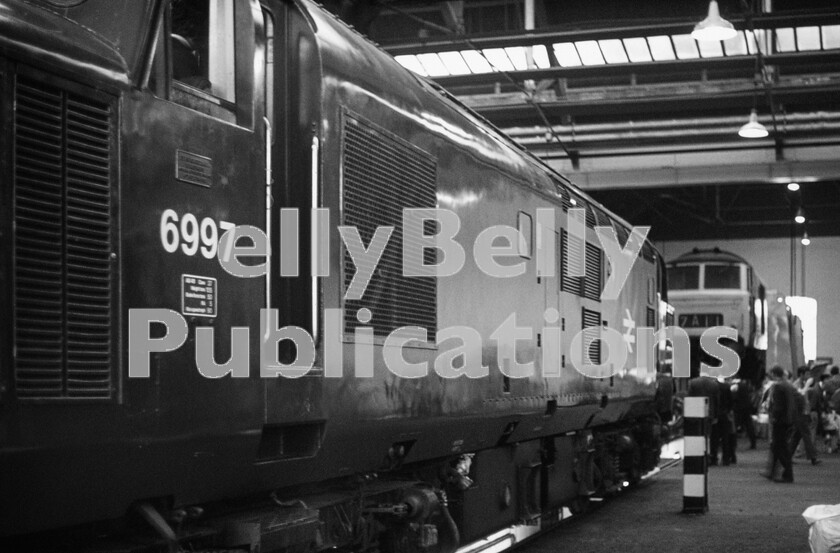 LPPC DSL CO 0175-Edit 
 Nicely turned out in the latest rail-blue livery, English Electric Type 3 Class 37 strangely has had its original number  6997  reapplied instead of a new TOPS number. There were many cases of non-standard finishes on many different types of locomotives from all of the works on BR. Nice to know the corporate accountants tentacles didnt get everywhere. In the background is a Hymek on jacks, probably having parts removed as a cannibalisation process to keep the dwindling number of these locos still surviving in action. The Class 37 became 37297 in the TOPS renumbering scheme and was later re-built as 37420 in the latter half of 1985 as steam heated coaching stock was eradicated from the BR network. The locomotive survived until 2008 before being cut up. 
 Keywords: BR, Western, Swindon Works, Class 37, 6997, 37297, 37420, 1971