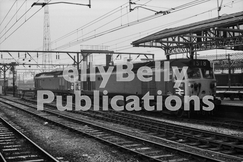 LPPC DSL BW 1235 
 In many ways, this shot shows just how advanced the electrified railway is compared to one powered by diesel locomotives. The extreme length of these two Class 50 diesels with number 432 nearest the camera were not just there to impress. Their combined power of 5500hp was required by the new WCML timetable in the days immediately prior to the overall electrification of the whole line from Crewe to Glasgow, or, more strictly speaking, from Weaver Junction in order to keep time with the most prestigious trains. Here, they have uncoupled smartly from the southbound Royal Scot to be replaced by one comparatively small Class 86 seen waiting on the left of the picture which was all that was required under the wires. 
 Keywords: Digital, ISO, John Stiles