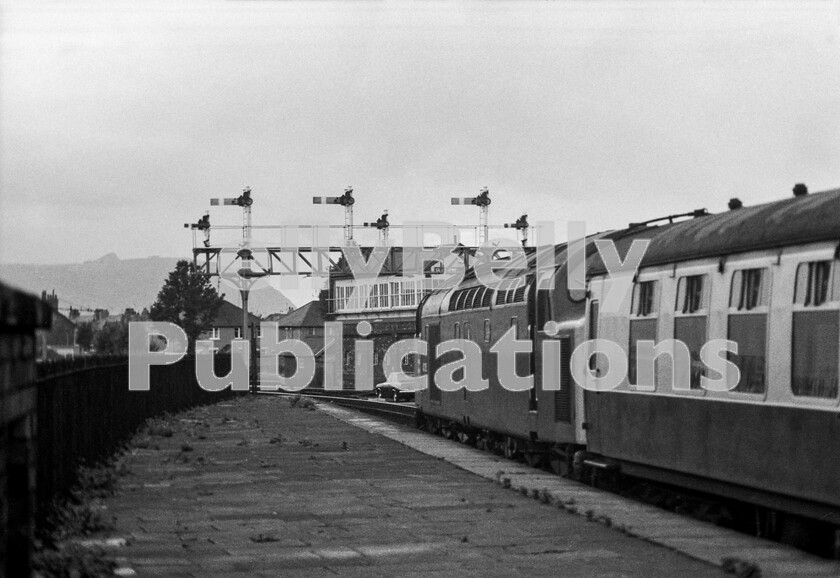 LPPC DSL BW 00718 
 The signalman at Llandudno has found a neat place to park his Mark 1 Ford Escort whilst the participants of a railtour are about to enjoy a scenic trip down to Blaenau Ffestiniog. Their trusty English Electric Type 4 Class 40 possibly 40035, ringing away waiting for departure time. Visually, the signalbox here is almost a replica of that at Llandudno Junction a few miles south of the eponymous seaside town itself.