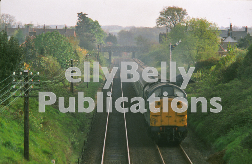 LPAP-DSL-CO-0045 
 The 07:22 Lowetoft - London storms up Beccles bank, with 37088 at the helm, 11th May 1984. 
 Keywords: BR, Eastern, LNER, Suffolk, Beccles, Diesel, BR, Passenger, Colour, Class37, 37088, D6788, TI, 1984