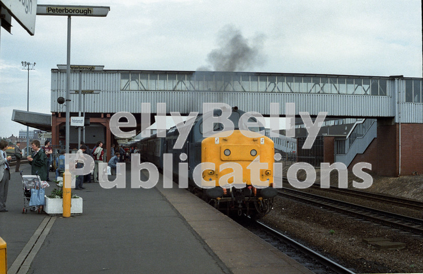 LPAP-DSL-CO-0071 
 Clagging away from Peterborough, with vans to Thornton fields, 37140 darkens the sky, 21st July 1984. 
 Keywords: BR, Eastern, LNER, Cambridgeshire, Peterborough, Diesel, BR, Parcels, Colour, Class37, 37140, D6740, TI, 1984