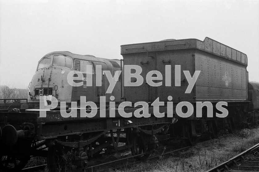 LPPC DSL BW 0967 
 Forlorn and unloved, Warship Class 43 number 852 Tenacious, no longer living up to its name, languishes in the scrapyard at Swindon Works on a cold and misty winters day, with only a Collett tender and a Diesel Brake Tender for company. The very short wheelbase wagon in the foreground looks like a mobile-crane match-wagon. We tend to think of the very short lives of some of the Standard classes of steam locomotive as scandalous, but the elimination at all costs of diesel-hydraulics after a decade of use should be considered equally wasteful. 
 Keywords: BR, Western, Scrap, Swindon Works, Withdrawn, 852, 'Tenacious', Class 43