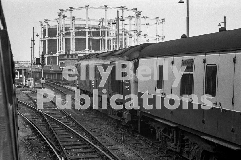 LPPC DSL BW 0495 
 At St Pancras station, early on the morning of Saturday June 17th 1972, we were waiting in the train that was due to leave at 07.40 when, unexpectedly, Sulzer Type 2 Class 25 number 5220, bearing the scars of a close encounter, clanked its way past the gasometers, now converted into bijou apartments as part of the Coal Drop Yard gentrification project, onto the rake of stock adjacent to us. Acting like an old school station pilot it coupled up and is here heading the coaches off to Cricklewood Carriage Sidings. Our train was one of two, a Blue train and a Red train and we were the latter. Both were named Steam Safari and the tour was part of the return to steam of A4 4498 Sir Nigel Gresley. At the head of this leg, which ran via York to Newcastle, was Sulzer Type 4 Peak Class 45 number 72, then it would be steam to Carlisle followed by return over Ais Gill and the Settle and Carlisle, headed by another Peak, number 118. Note the disused siding to the wagon lift allowing the lowering of wagons to the station undercroft which was a bonded warehouse and now the Eurostar border check and waiting area. 
 Keywords: Digital, Rights Managed, Stock